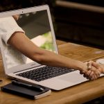hand shaking through laptop screen