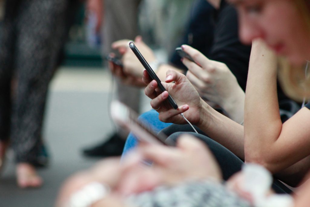 crowd of people typing on iphones