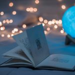 magic ball with open book and string lights