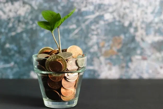 Glass of coins with plant