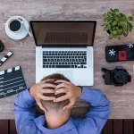 Head in Hands front of laptop